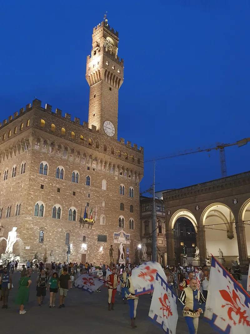 Calcio Storico Fiorentino Firenze: corteo notturno in Piazza della Signoria con Palazzo Vecchio illuminato — giugno 2026