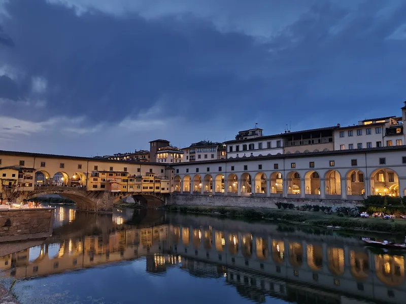 Cena all'aperto sul Lungarno di Firenze con vista sugli Uffizi illuminati di notte