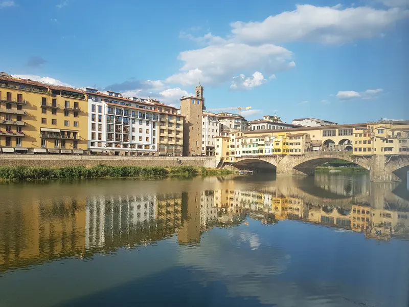 Ponte Vecchio Firenze al tramonto: riflessi dorati sull'Arno — iconico monumento del centro storico